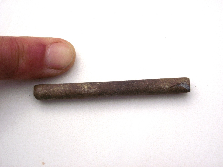 This is a silver coloured metal, like a fine bore tube but it isn't sealed, there is a tiny crack all the way along its length, so it was shaped into a tube but not sealed.